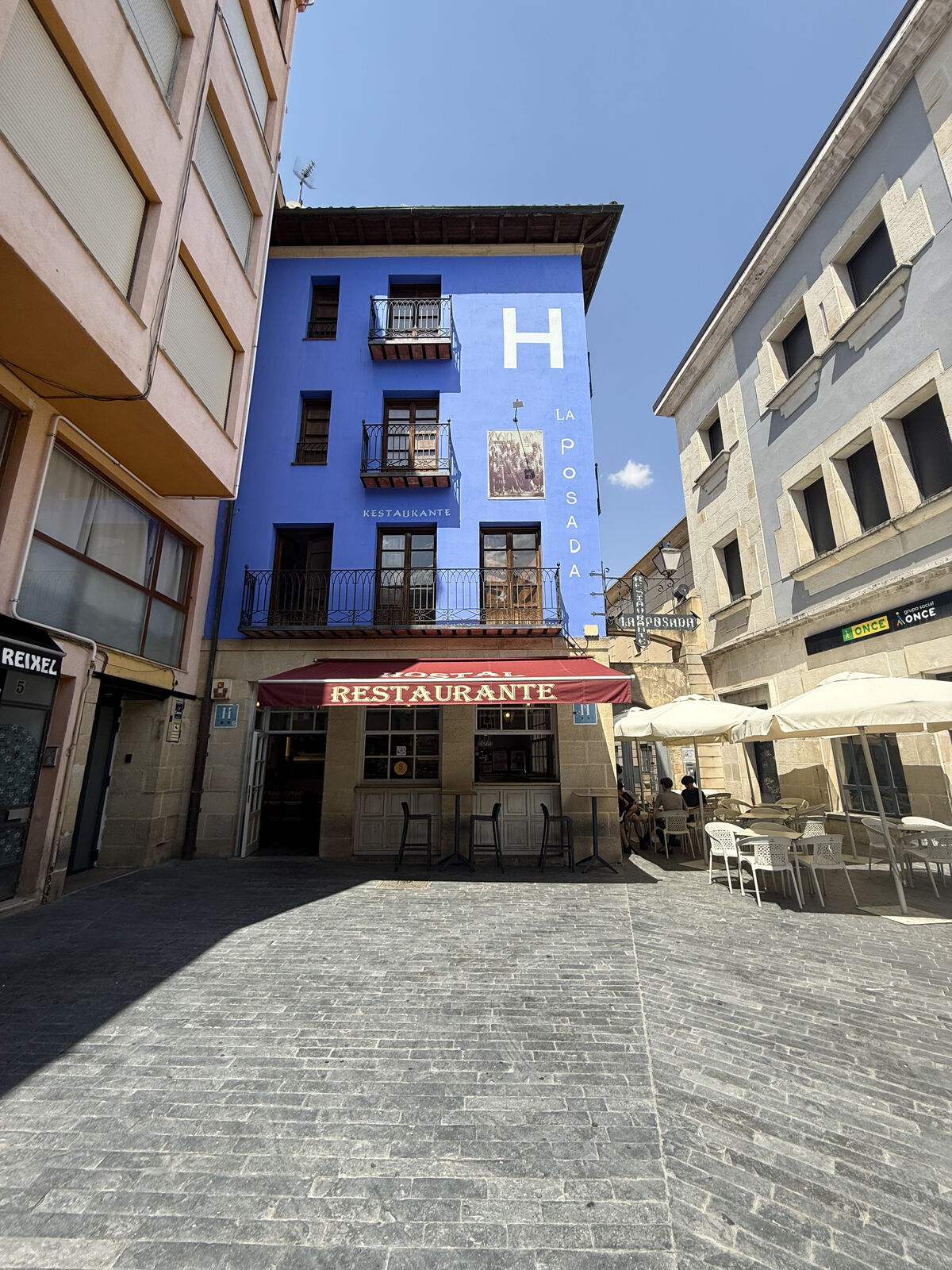 Fachada azul del Hostal La Posada en la Plaza de San Clemente