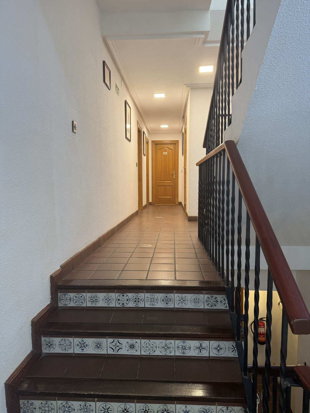 Pasillo con escalera de azulejo del Hostal La Posada